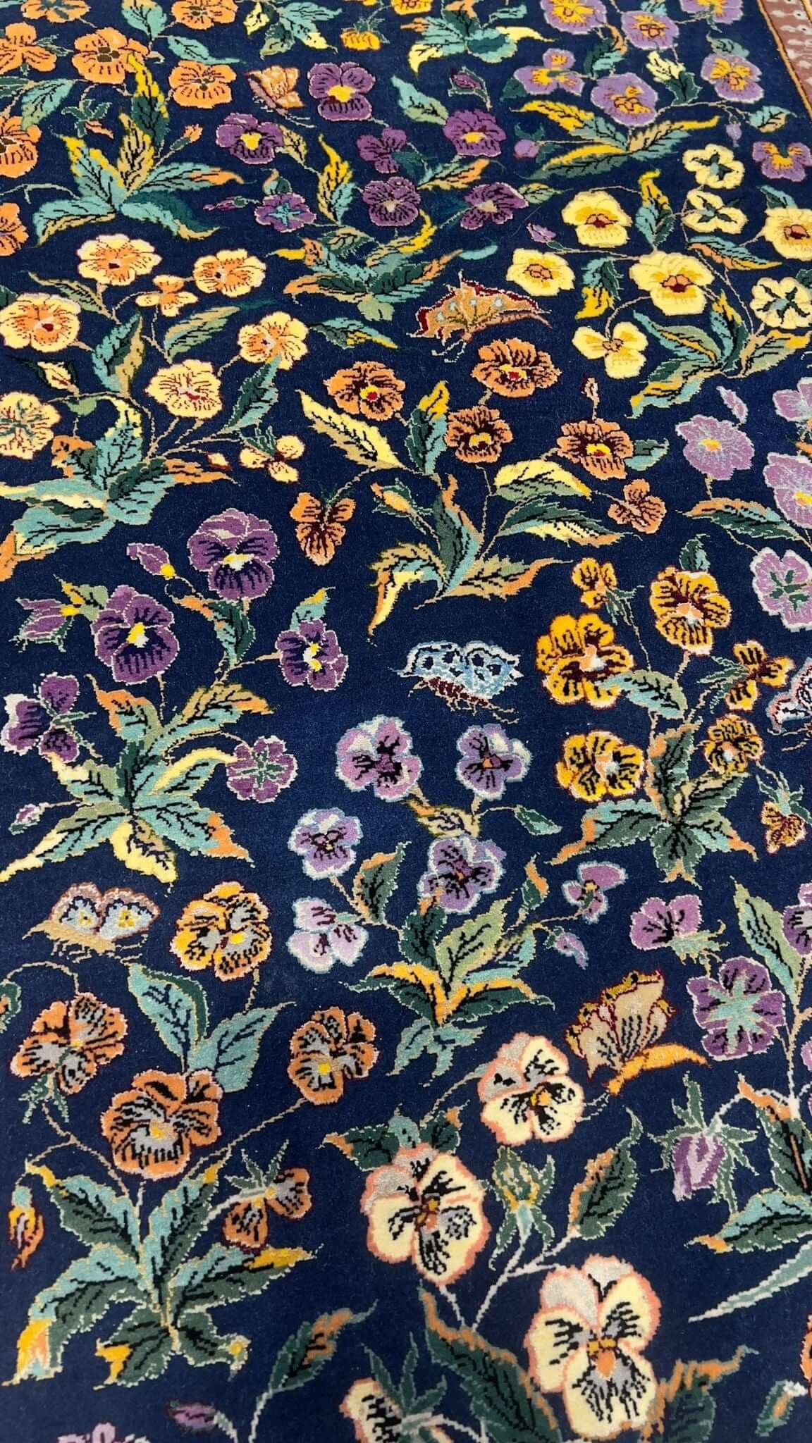 Elegant Persian rug featuring intricate floral and garden motifs.